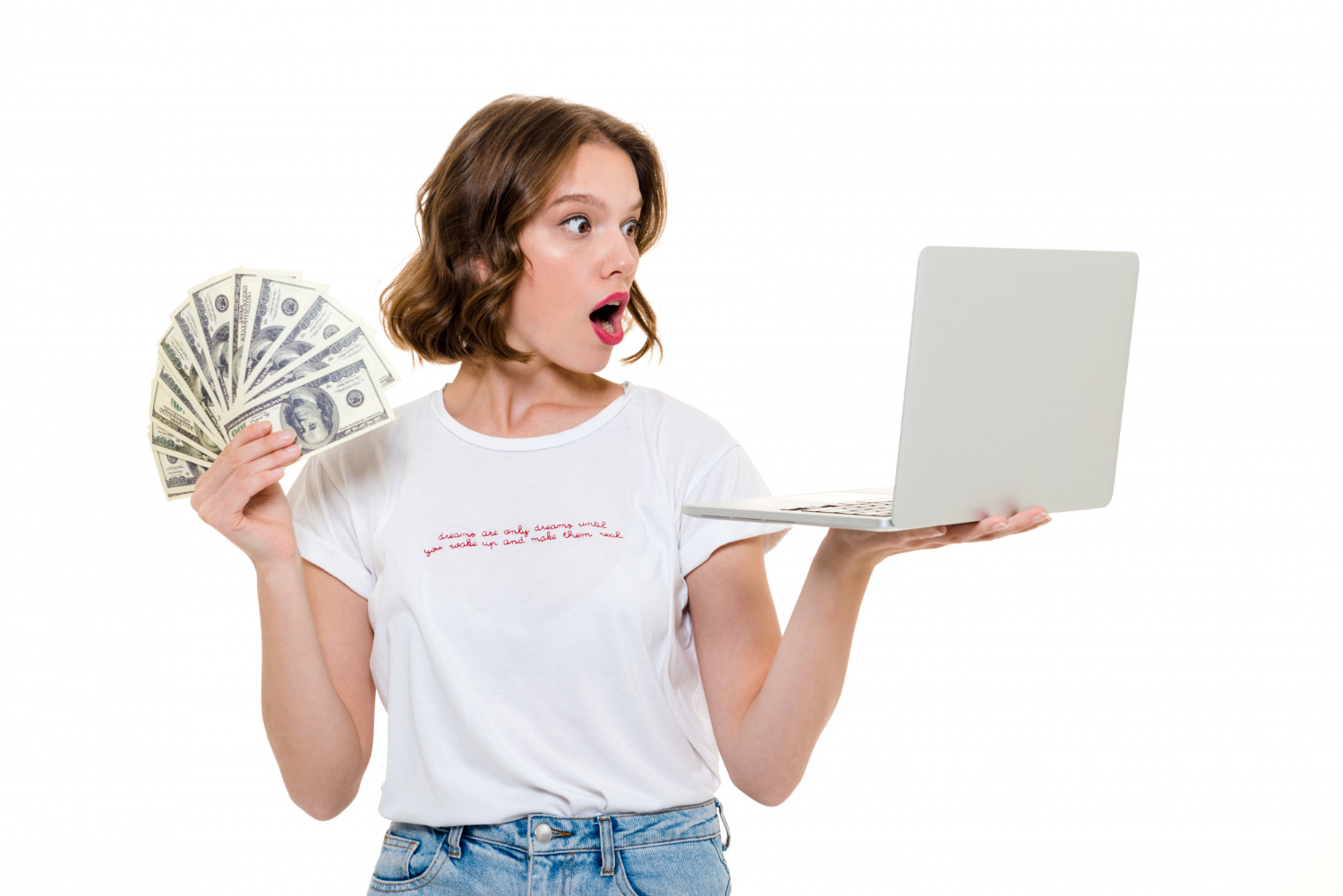 Fiatal nő laptopot tart és pénzt mutat – online pénzkeresés meglepett arckifejezéssel