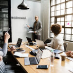 Csapat meeting közben, menedzser prezentációt tart – digitális menedzsment munka bemutatása