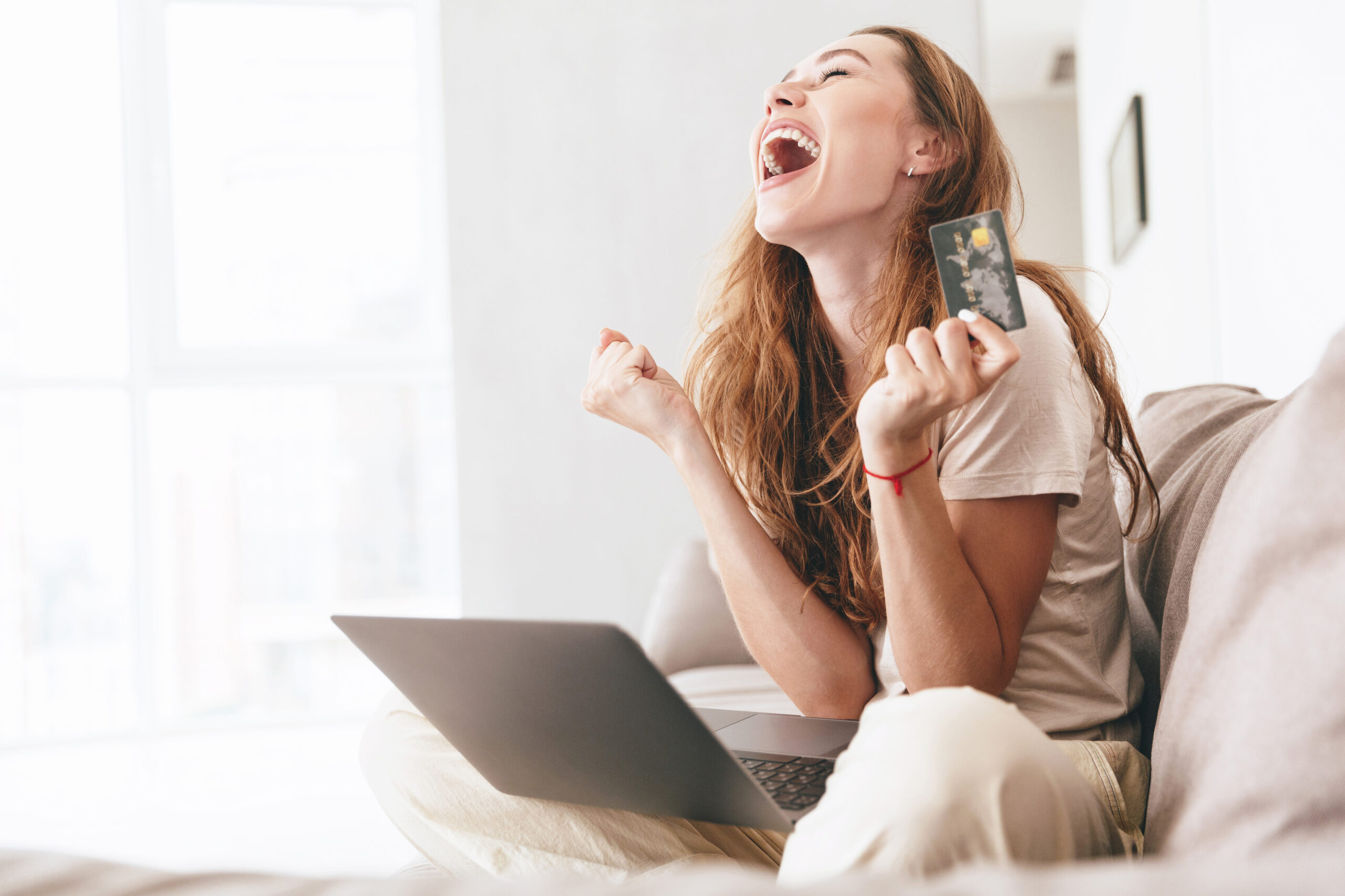 Mosolygó nő laptop előtt – a pénzügyi szabadság szimbóluma