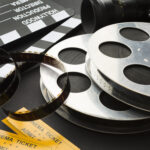 Régi filmes tekercsek, vágócsapó és mozijegyek egy filmes blogcikk illusztrációjához